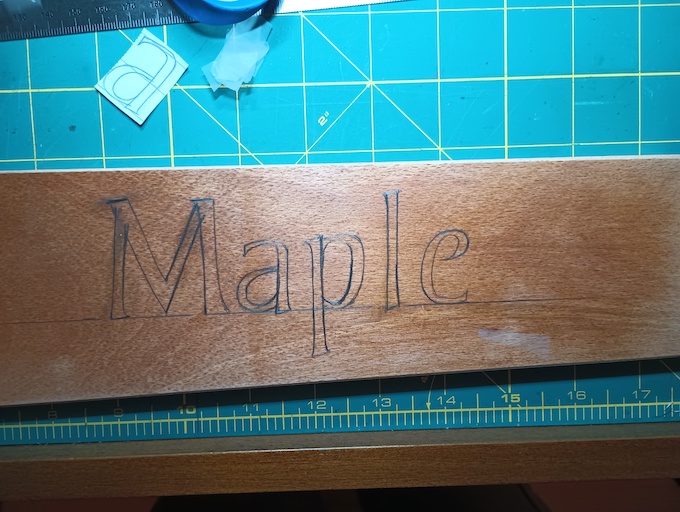 Letters penciled on wood